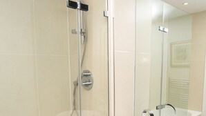 A modern bathroom with a glass-enclosed shower, a white sink, and a large mirror. - Modern Edwardian, by Veeve (London)