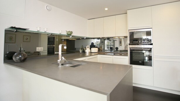 A modern kitchen with a central island, stainless steel appliances, and white cabinetry. - Modern Edwardian, by Veeve (London)