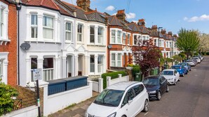 A row of terraced houses with a parking area in front. - Clapham Fairytale, by Veeve (London)