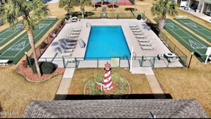 Piscina com espreguiçadeiras e quadra de bocha.