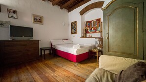 A bedroom with a bed, a television, wooden flooring, and a wardrobe. - HbHall - Navigli 2 Apartment  (Milan)