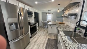 A modern kitchen with stainless steel appliances, a granite countertop, and a built-in oven.