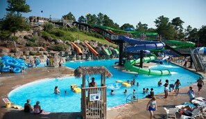 Um parque aquático com várias escorregas e uma piscina.