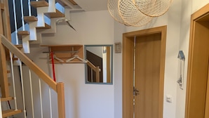 Een trap met houten leuningen en een spiegel aan de muur.