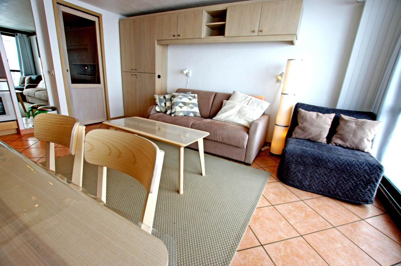 A compact living space with a sofa, a dining table, and a small kitchenette.