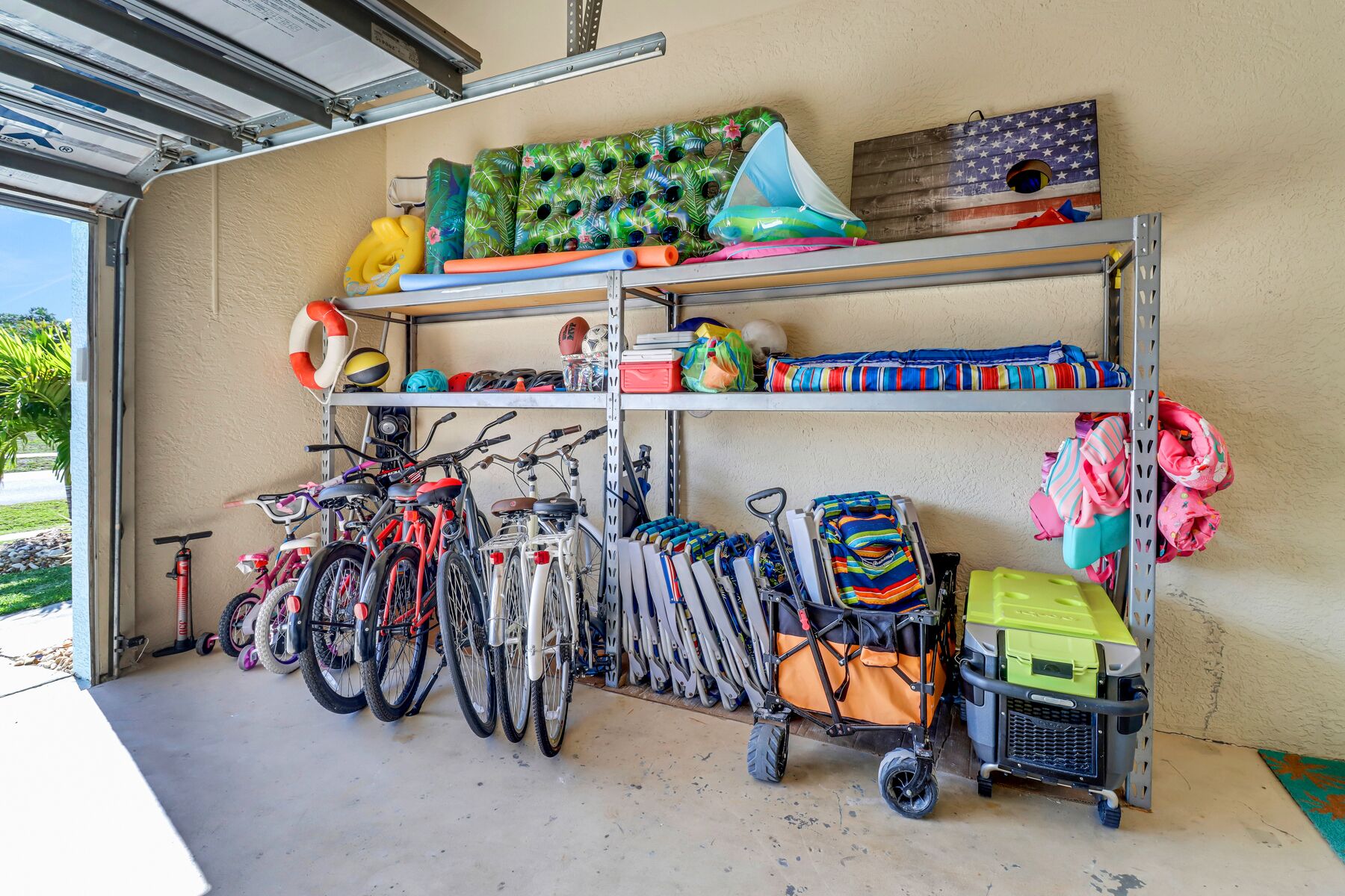 A garage with bicycles, a tricycle, and a stroller.