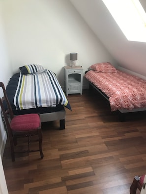 A small, well-lit room with two beds, a chair, a nightstand, and a lamp. - Gite Verronnerie 4 / 6 pers near A85, Beauval, Chenonceau (Bléré)