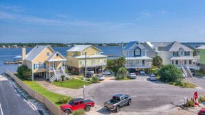 A coastal residential area with houses, a dock, and a clear view of the water. - Lagoon Landing 305 1 Bedroom Condo by RedAwning (Gulf Shores)