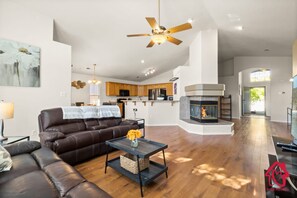 A modern living room with a leather sofa, a coffee table with a vase, and a fireplace.