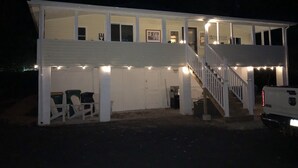 Ein zweigeschossiges Haus mit einer Veranda und einer Treppe, die zum oberen Stockwerk führt.