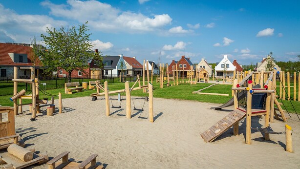 A playground with various wooden structures and a sandy area, surrounded by houses with different architectural styles. - Kids Special 6p - Three Bedroom Villa, Sleeps 6 (Thorn)