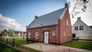 A brick building with a sloped roof, a door, and windows. - Kids Special 6p - Three Bedroom Villa, Sleeps 6 (Thorn)