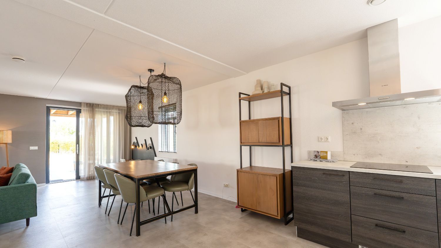 Eine moderne Küche mit Essbereich, Holzschränken und Pendelleuchten.