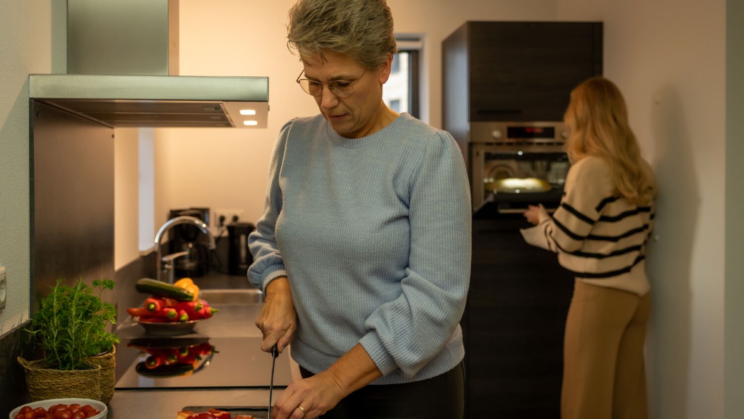 Een keuken met een fornuis, gootsteen en diverse keukenbenodigdheden.