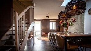 A modern interior with a staircase, dining area, and large windows. - Lake View Maisonette 4p (Thorn)