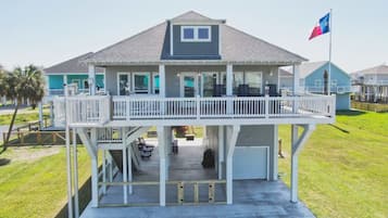 A two-story house with a balcony, a garage, and a flag.