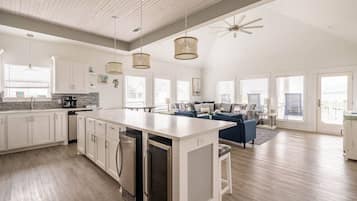 A spacious kitchen with white cabinetry, a central island, and pendant lighting.