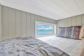 A bedroom with a bed, a window, and a view of a body of water. - Channel Marker: Exclusive Lakefront Home w/Hot Tub, Custom Bunk Room, Dock & Optional Boat Rental (Mooresville)