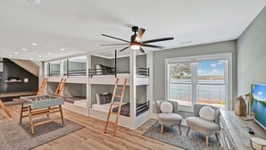 Un intérieur moderne avec des lits superposés, un baby-foot et un téléviseur.