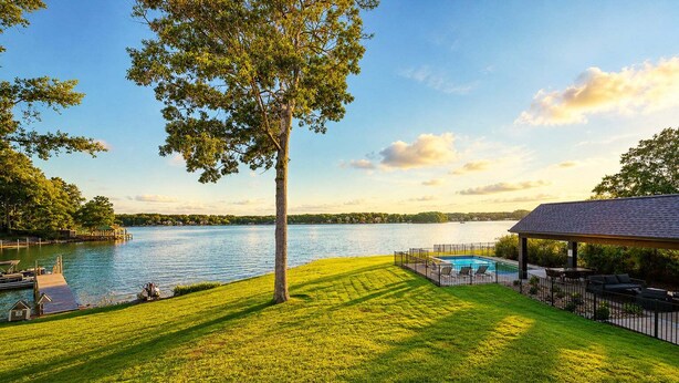 Une propriété située au bord d’un lac, dotée d’une piscine, d’un patio couvert et d’un quai.