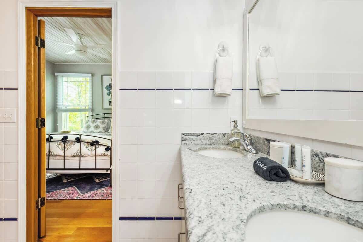 Une salle de bain avec un double lavabo, un miroir et un porte-serviettes.