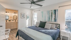 Ein Schlafzimmer mit Bett, Nachttisch und Deckenventilator.
