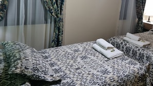 A hotel room with a bed, two pillows, a nightstand, and a window with curtains. - Duplex Equipped, with daily cleaning service  (Malargüe)