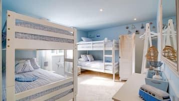 A bunk bed room with a desk and a mirror.