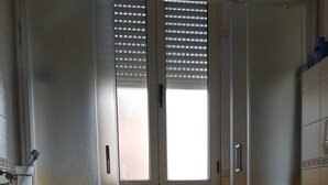 A bathroom with a shower enclosure, a toilet, and a sink. - Apartment from helium (La Caletta)