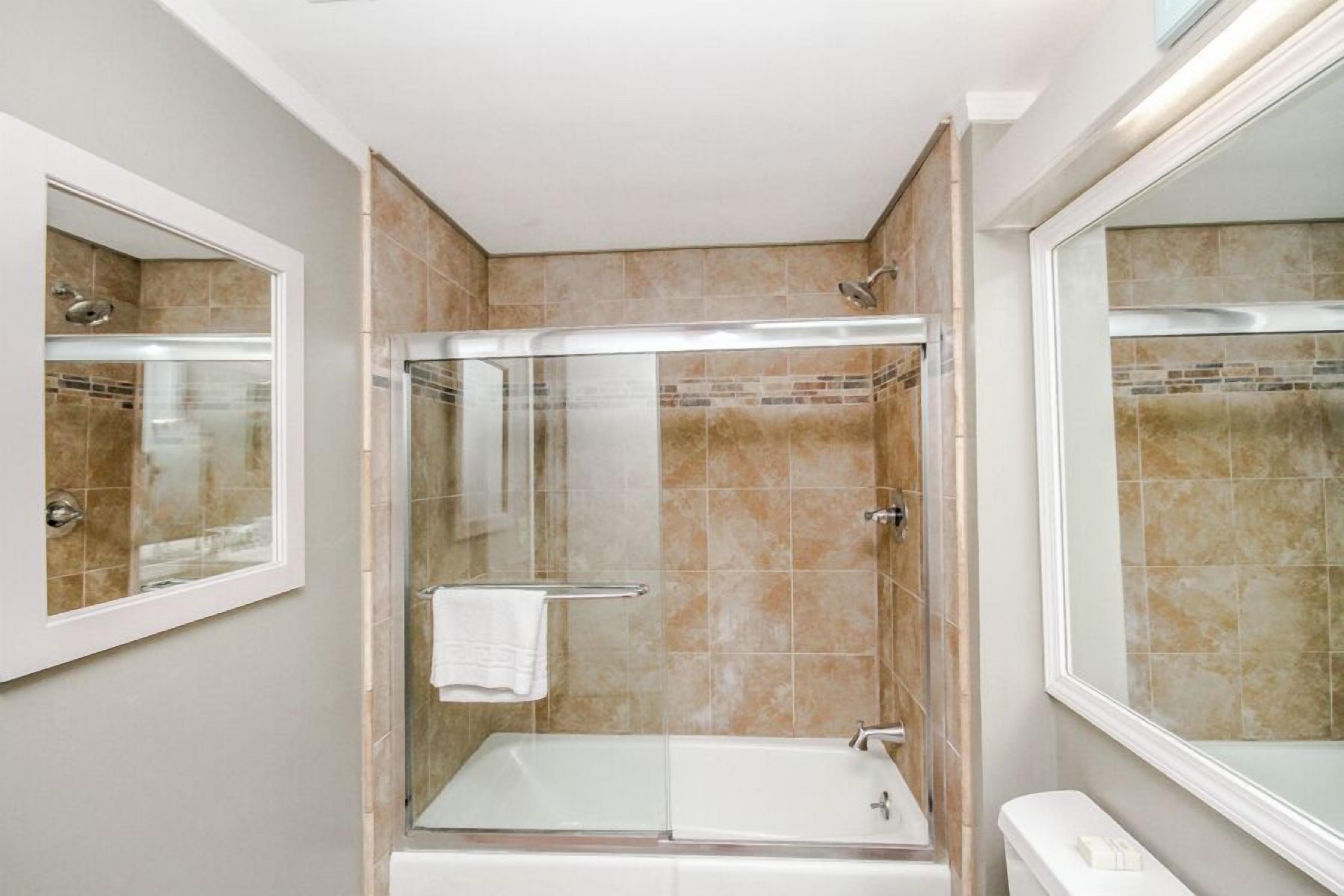 Ein modernes Badezimmer mit einer Duschkabine, einer freistehenden Badewanne und einem WC.