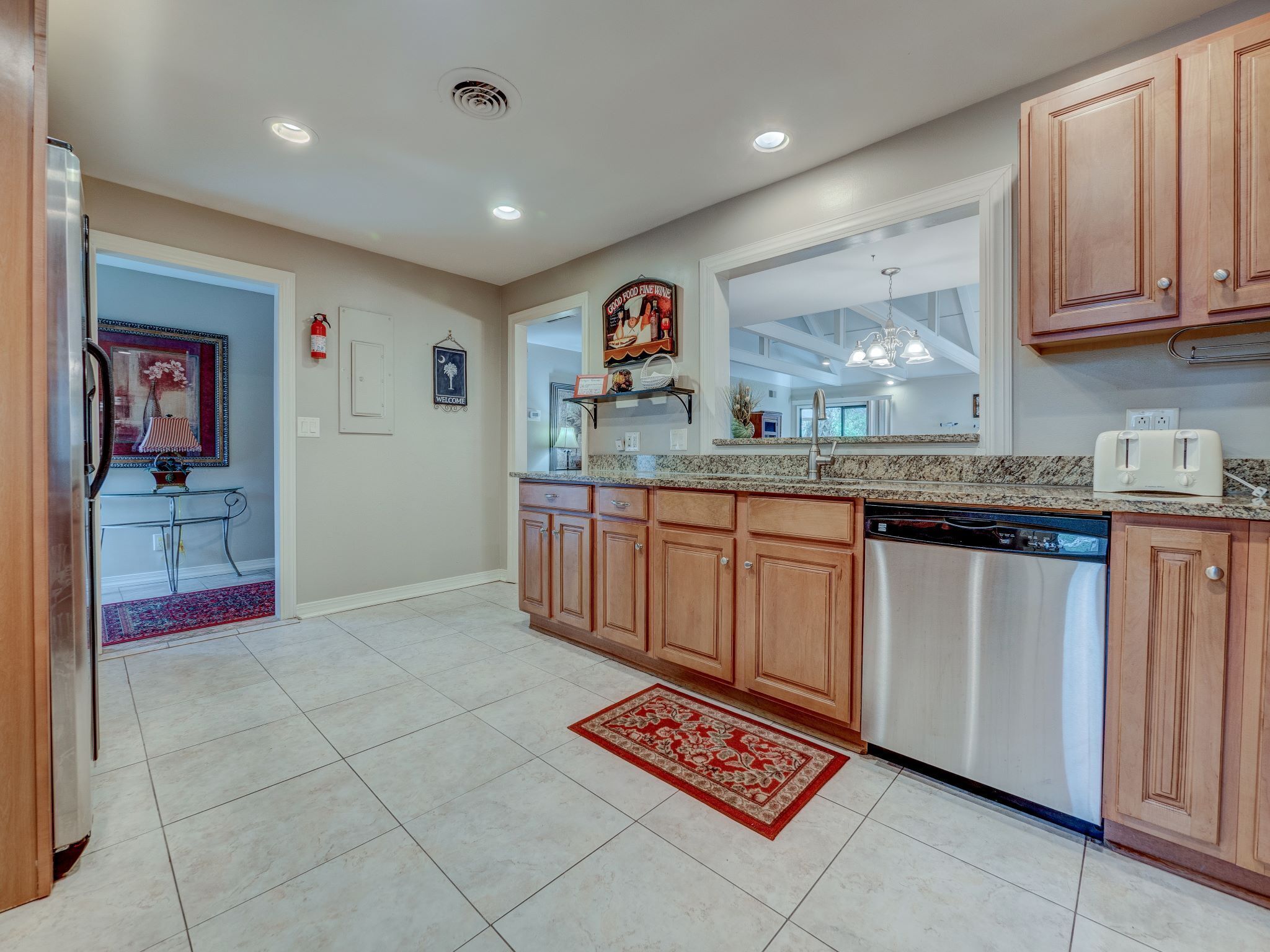 A modern kitchen with wooden cabinets, stainless steel appliances, and a granite countertop.