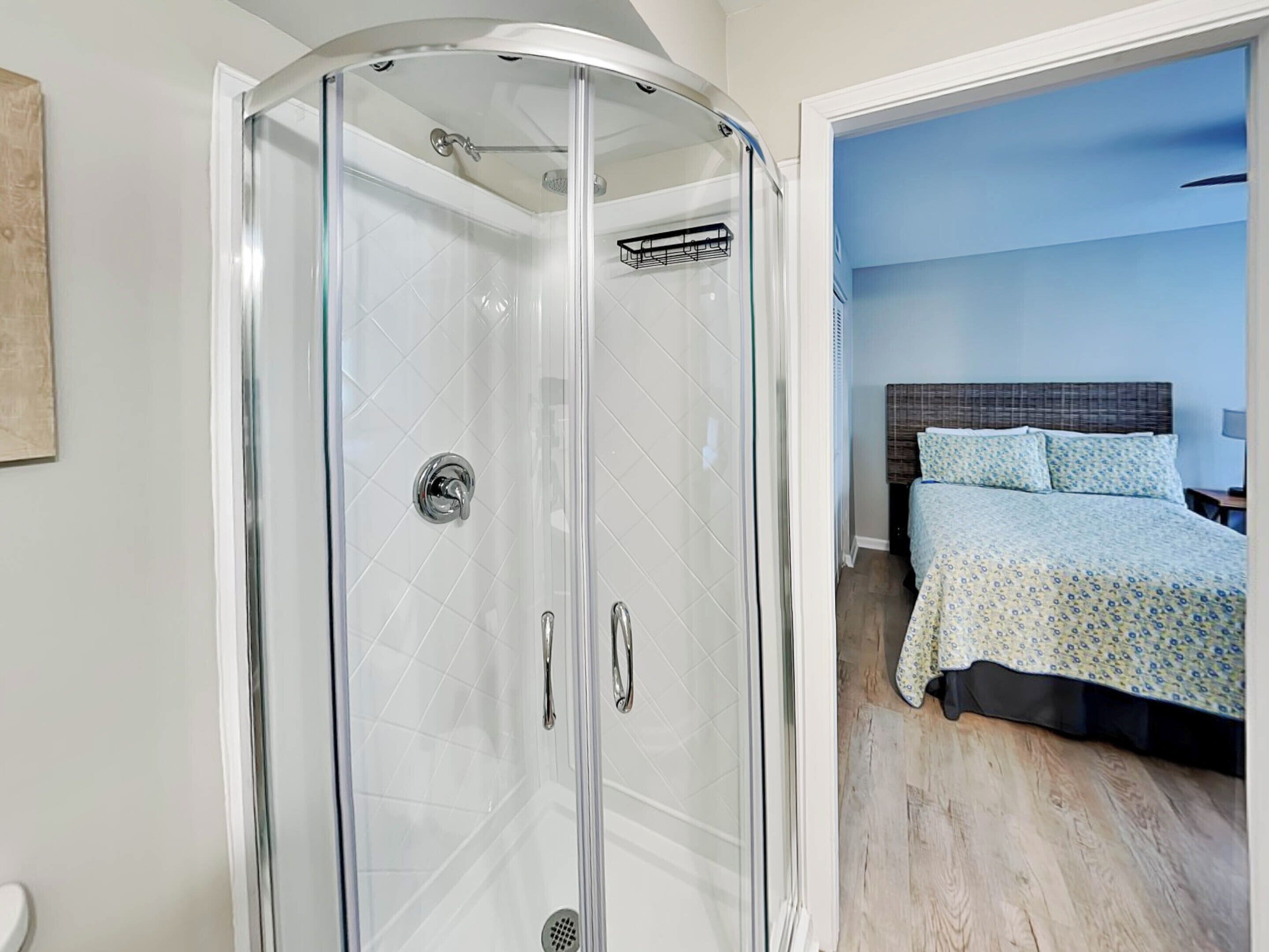 A modern bathroom with a glass-enclosed shower and a visible toilet.