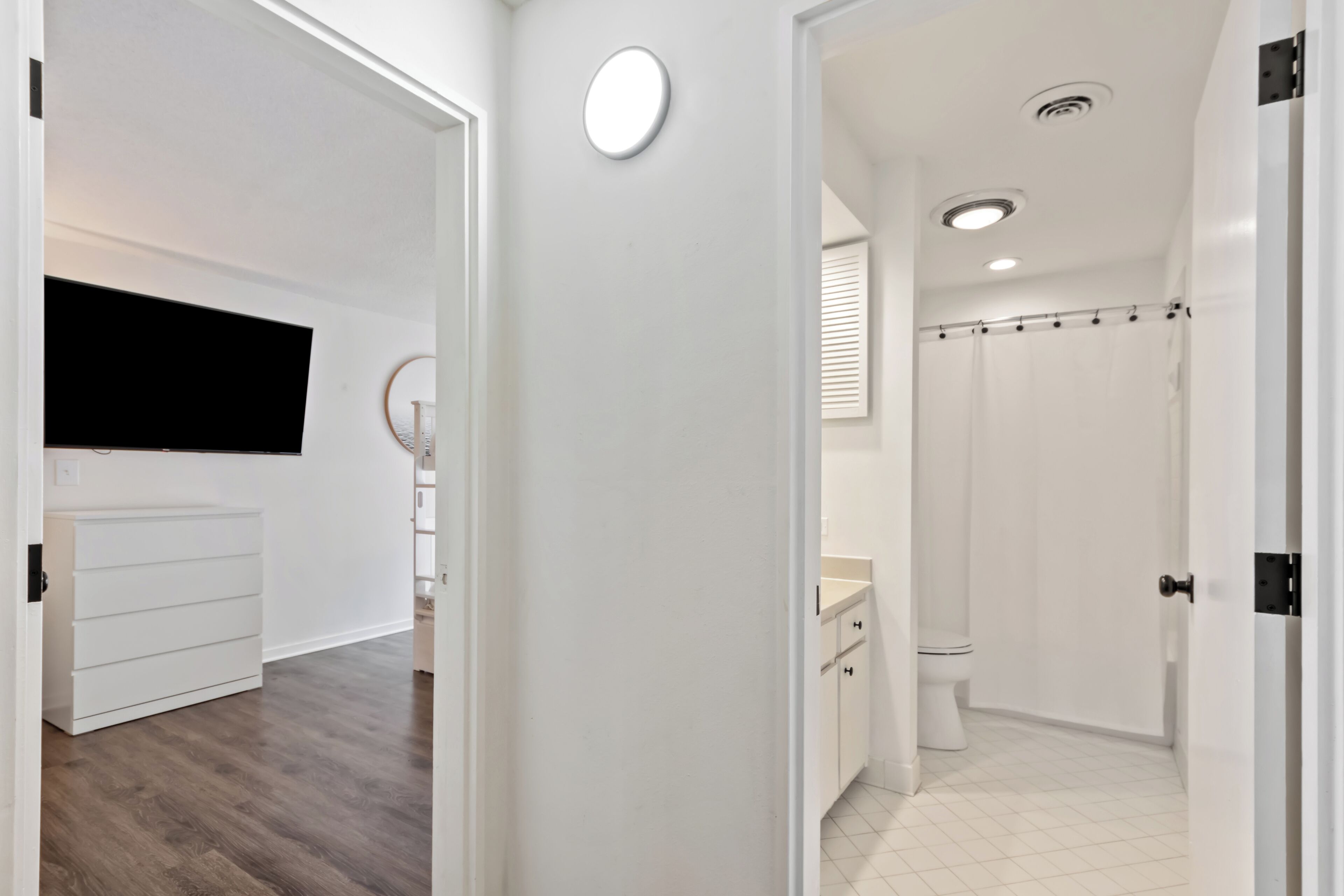 A modern bathroom with a toilet, shower, and sink.