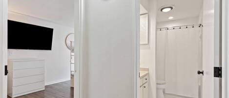 A modern bathroom with a toilet, shower, and sink.