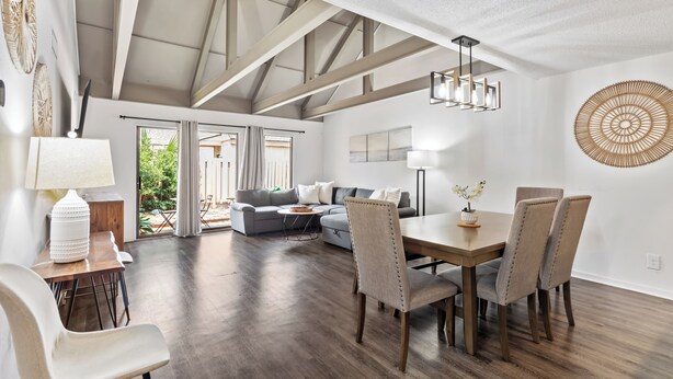 A spacious living area with a dining table, chairs, and a sofa. - Queens Grant by Hilton Head Retreats (Hilton Head Island)