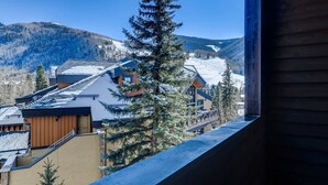 A mountain lodge with a ski slope in the background, wooden cabins, and a snow-covered landscape. - Tyrolean 6 (Vail)