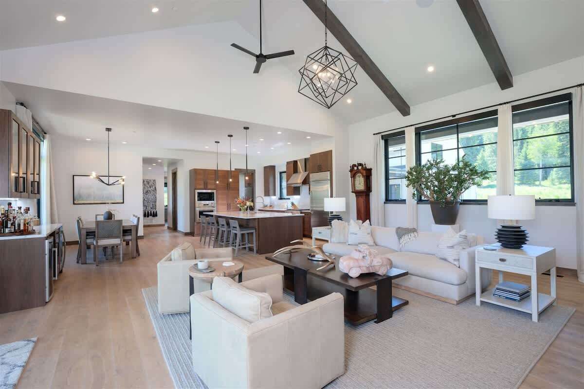 A spacious living area with a dining table, sofas, and a kitchen in the background.