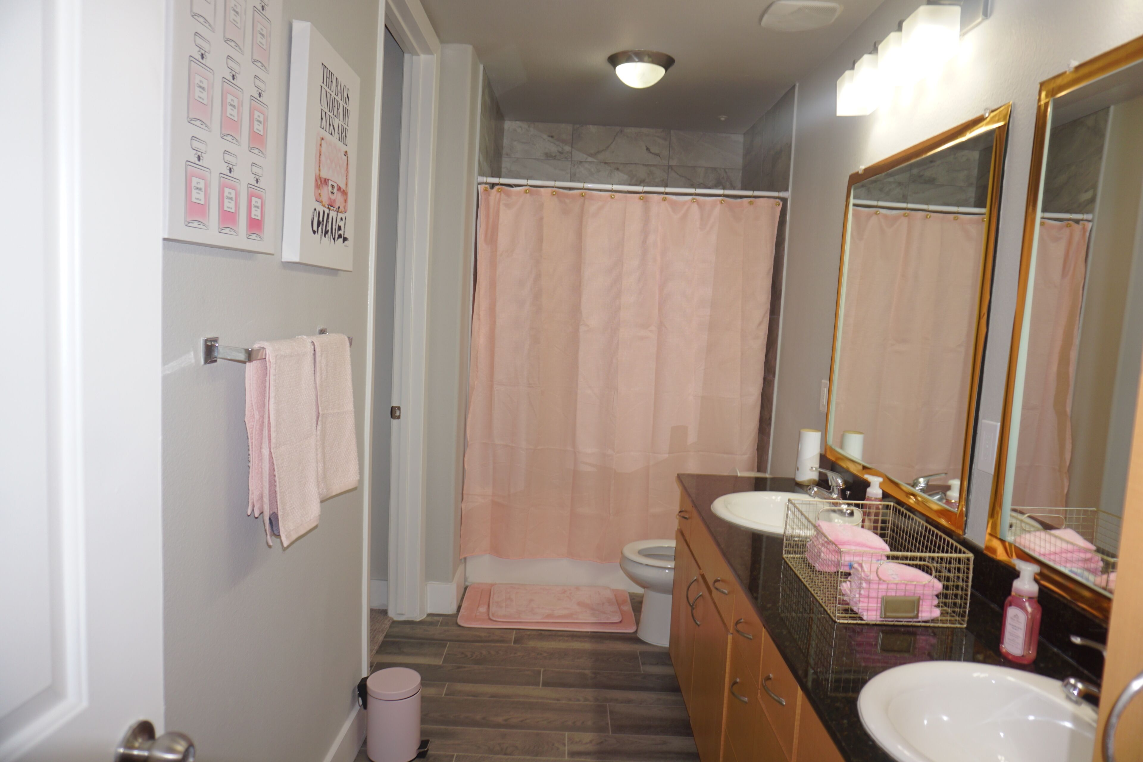 A bathroom with a shower, toilet, sink, and a mirror.