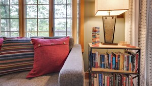 A cozy living room with a sofa, pillows, a bookshelf, and a lamp. - Ridge Run Retreat (White Haven)