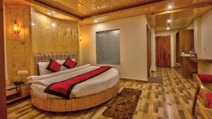 Una cama de madera redonda con cabecera, una mesita de noche y un buró.