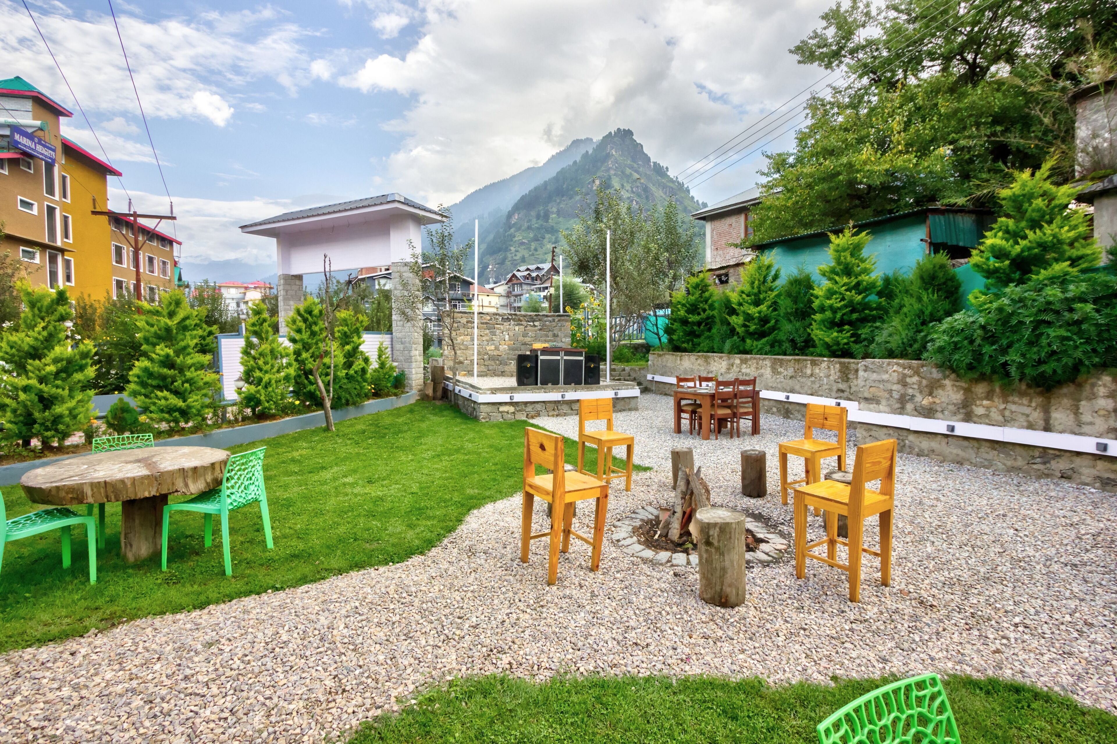 A courtyard with a fire pit, outdoor seating, and a mountain view.