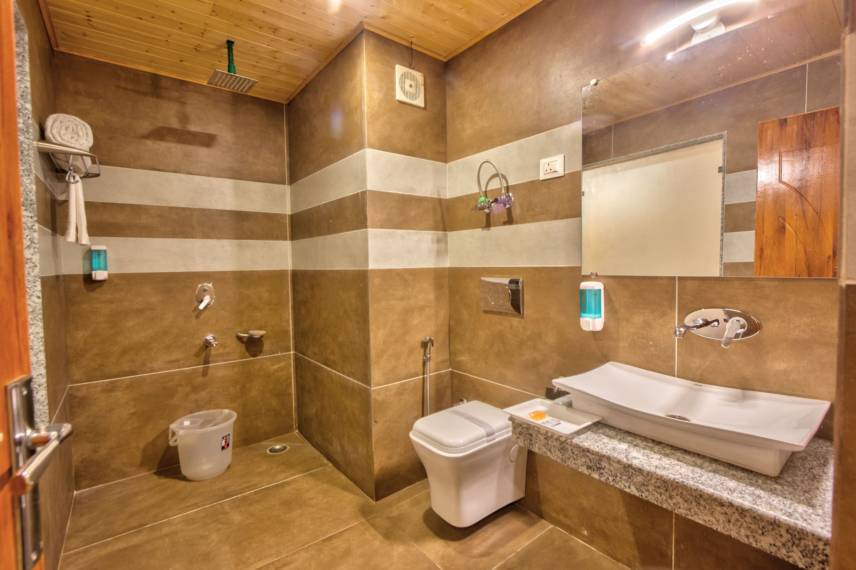 A modern bathroom with a shower, toilet, sink, and a large mirror.