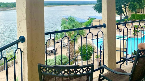 Un balcón con vista a un lago y una piscina.