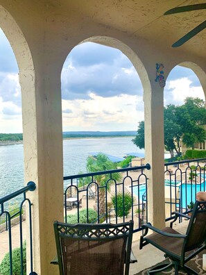 Un balcon avec vue sur un lac et une piscine.