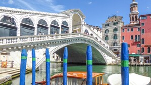 Un puente histórico sobre un canal con un barco amarrado cerca.