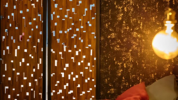 A bedroom with a bed, pillows, and a wall with a textured pattern. - Suite-Designer-Whirlpool bath (Saint-Blimont)