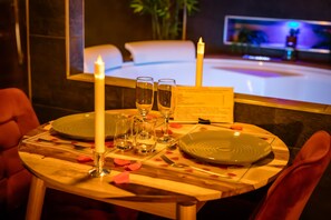 A dining table set with candles, glasses, and a menu. - Suite-Designer-Whirlpool bath (Saint-Blimont)