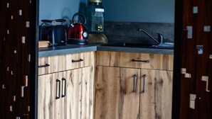 A kitchen with wooden cabinets, a countertop, and a hexagonal tile floor. - Suite-Designer-Whirlpool bath (Saint-Blimont)