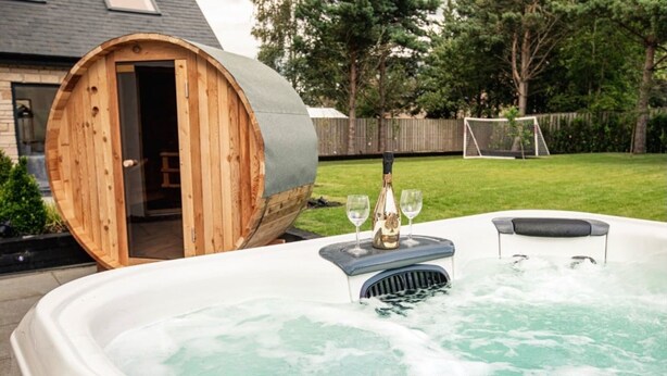 A hot tub with a wooden barrel structure in the background.