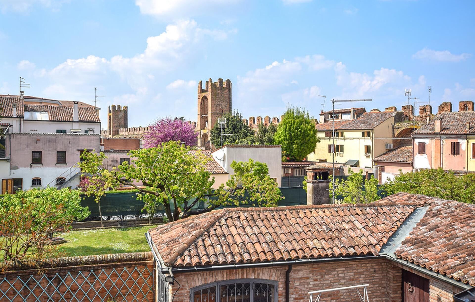 Un pueblo histórico con arquitectura tradicional, incluyendo una torre destacada y edificios con tejados de teja de barro.